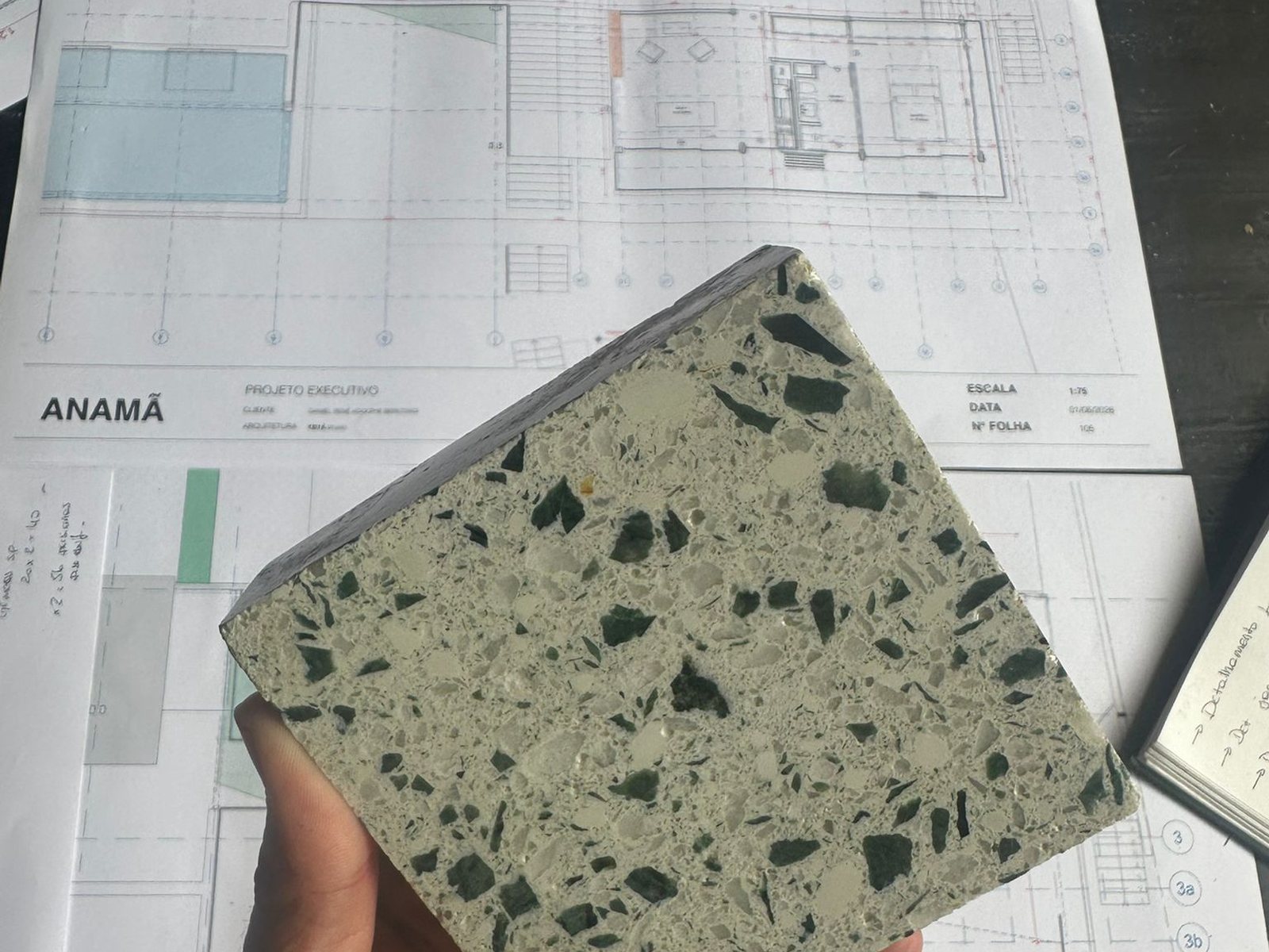 Amostra de terrazzo feita com sobras de mármore, na mão, sobre o projeto