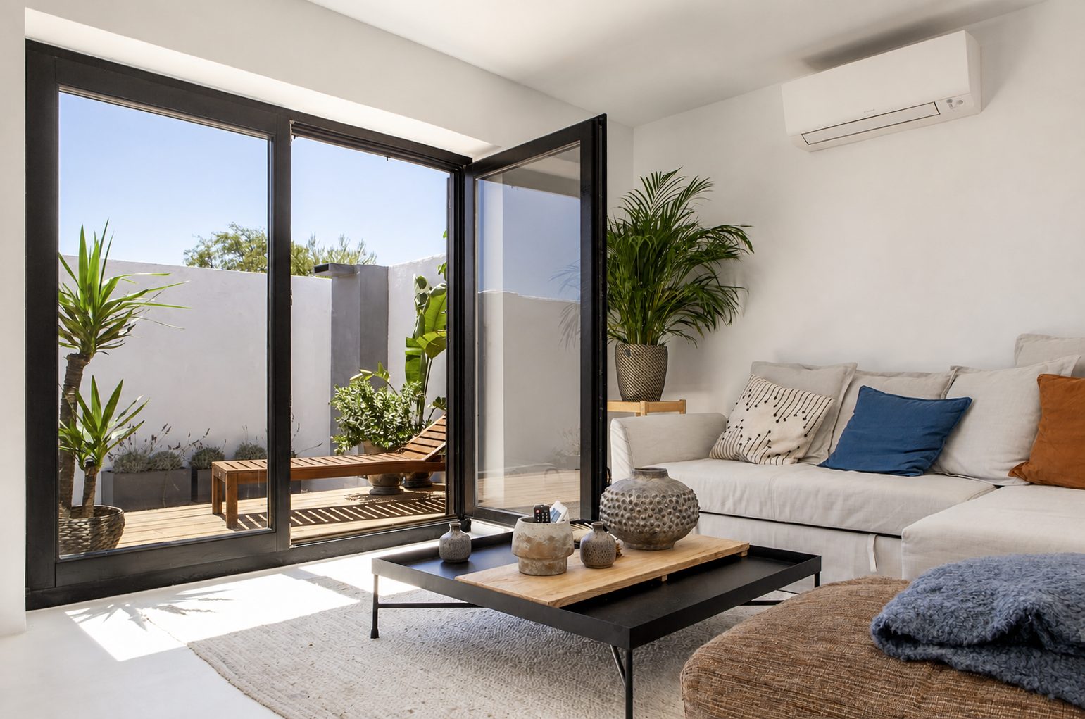 Sala aberta para o pátio, com sofá e mesa de centro